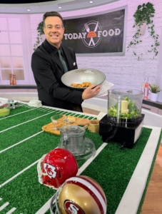 Here's host Carson Daly helping me toss the sauce with the wings.