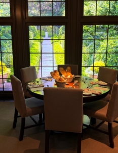 These tables are surrounded by floor to ceiling windows that look out to Durantrans, or large backlit transparency photos, of my farm. This background shows my Summer House Spring Garden. And of course, everything is changed seasonally.