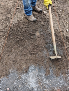 Using a hoe, Pete removes any leftover weeds, or small rocks from the area.