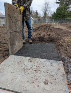 Once it is brought to the location, Pete carefully lines up the stone paver over the space...