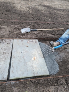 Pete uses a fork to make minor adjustments to the stone. These pavers are very heavy, so using the right tool is key to avoiding injury.