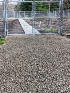 Outside the gate, Pete spreads native washed stone gravel. It looks great. Follow along and see the rest of the transformation. You'll love it.
