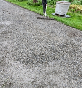 The gravel is dropped in small sections along the road for easy spreading. Pete uses a a landscape rake to spread and level the gravel.