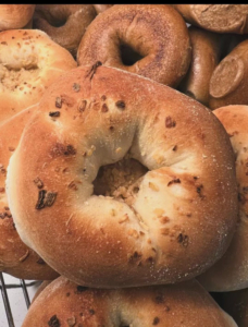 A bialy is a round, flat, cross between a bagel and an English muffin. It's made from flour, yeast, water, and salt, and has a crunchy crust on top and a chewier bottom. These are similar in shape and size to bagels, but they're not boiled before baking and have a depression in the center instead of a hole that's filled with seeds.