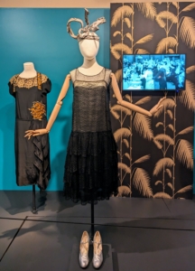 The headdress was a gift from the Irene Castle Collection. Castle was a pioneer in the creation of the ready-to-wear fashion movement. This black dance costume dates to around 1928 and is much more free and comfortable for the active wearer.