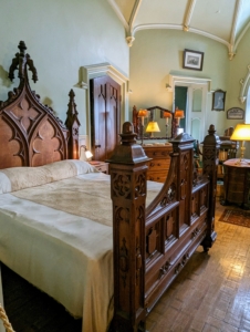 This is one of the bed chambers in the home. It includes a very ornate period bed.