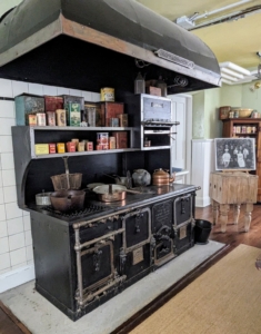 This is the large stove behind the kitchen table.