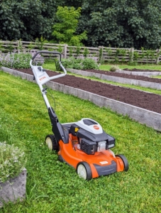 For those places, such as between my raised garden beds, we use this STIHL RM 655 VS push mower. A push mower is a walk behind unit that an operator pushes forward or backward to mow the lawn.