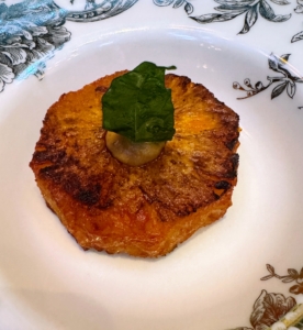 This very special dish is inspired by the harvest festivals of South India. It is spice roasted pineapple with coconut, lemon, mustard seeds, and curry leaves. This photo was taken just before the sauce was poured around the fruit.