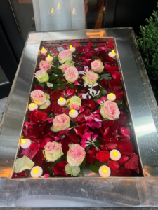 Outside the entrance to Bungalow are two large stainless steel vessels containing a bath of red rose petals, pink roses, and votives. This symbolizes femininity, beauty, strength, and fertility.