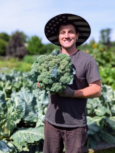 Ryan holds up one of the broccoli heads - it's huge, and weighs a good 10-pounds. Broccoli is a hardy vegetable that is high in vitamins A and D.