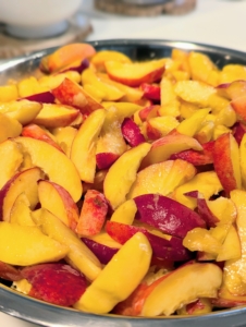 Once the peaches are brought into my Winter House kitchen, they are pitted and sliced into wedges, and placed in a large stainless steel bowl.