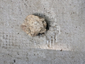 The hole at the bottom of the new pot is covered with a stone. I also use shards of broken pots. Doing this prevents soil from falling out as the water drains.