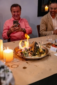 Chef Boulud takes a photo of the fish and vegetables fresh from the outdoor oven. (Photo by Charles Wills)