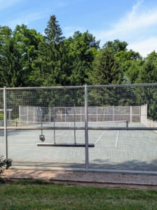 My tennis court in Bedford is tucked away in a far corner of my farm. The court is surrounded by the same type of fencing as my perennial flower garden. And like all the other structures on the farm, it is painted Bedford gray.