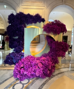 The lobby is decorated with dark purple and fuchsia flowers in a beautiful display by master floral designer Jeff Leatham.