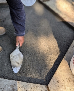 Using a trowel, the area is leveled with a one-inch fresh layer of stone dust.