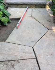 The crew checks the level on the paver again - this time it is just right.