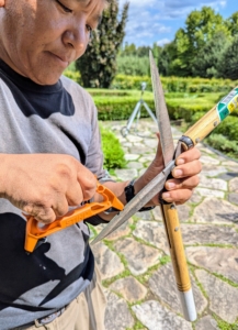 Every so often, Phurba stops to sharpen his tools. Here he is using his STIHL pruner, axe, and tool sharpener. It is crucial to always work with sharp tools in the garden. They make cleaner cuts that allow plants to heal faster and resist disease, insects, and poor weather. Dull blades can crush and tear plant tissue, which makes healing more difficult and increases the risk of infection.