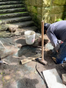 Old stone dust and debris are removed, the area is re-leveled and the paver is repositioned, dropped carefully in place on new stone dust, and checked for level again. If it is not perfectly level, it is removed and stone dust is added or taken away as needed. It is a trial and error process that takes lots of patience. All neighboring pavers are also checked.