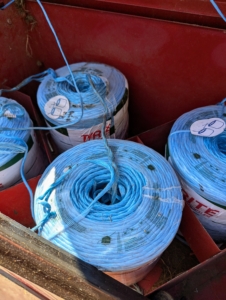 In one compartment, large rolls of twine are positioned and tied to each other, so they can feed into the baler and secure the hay just before it shoots out into the trailer. There are three choices of materials to wrap bales – twine, net wrap, or plastic wrap. If properly baled and stored, hay can last a long time without degrading in quality.