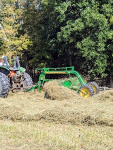 The bar rake, also known as a basket rake is hydraulically driven. This rake allows for consistent movement across the fields making well-shaped windrows. One can see how the machine pulls the hay to create a windrow.