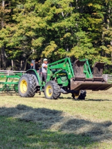 Phurba creates the windrows around the fields as Chhiring sets up the next step, the baler.