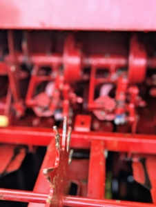 The spiked wheel grabs the bale and with the motor helps to move and propel the bales through the baler.