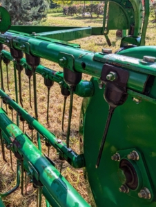 This apparatus also has tines that pick up the hay and sweep it into the long rows around the field.