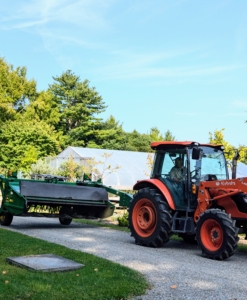 Once the hay baling equipment is cleaned and adequately sun dried, it is all pulled one by one behind the tractor to the barn specifically designated for these pieces.