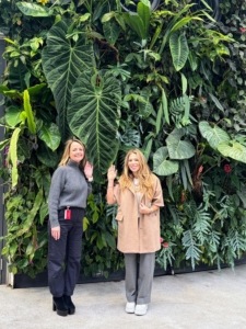 Heather Kirkland and Daisy Schwartzberg Toye from my traveling team are standing in front of a living wall and the giant leaf of Anthurium queremalense, a very rare specimen native to the tropical rainforests of South America, particularly in regions like Colombia. This plant produces some of the largest and most impressive foliage in the genus.