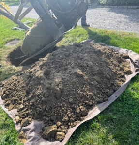 The crew uses a tarp to collect the soil from the hole. This makes cleanup much easier and much more efficient.