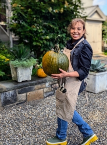 Elvira places the pumpkins on the wall outside my home.