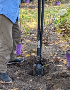 Cesar starts digging the holes. Because these holes do not have to be too deep, he uses a post hole digger.