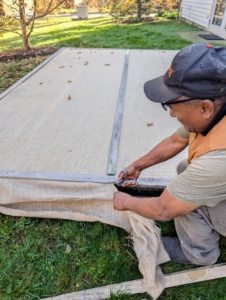 The burlap is trimmed and then held down with wooden strips. It looks very finished and tidy.