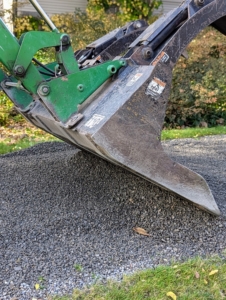 In some areas, Pete uses the tractor bucket to level and spread the gravel.