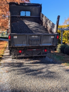 My farm has four miles of gravel-covered carriage road. Gravel roads are attractive and accumulate less pollutants over time, but it is important to keep them well-maintained. Here's one of the trucks from Bedford Stone & Masonry Supply Corp. As it moves along the carriage road, the gravel is released from the bottom of the truck's tailgate very slowly and evenly.