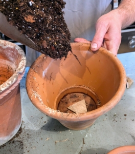 Here, Ryan begins to fill the pot with the appropriate mixed medium. Just a scoop to cover the bottom is sufficient.