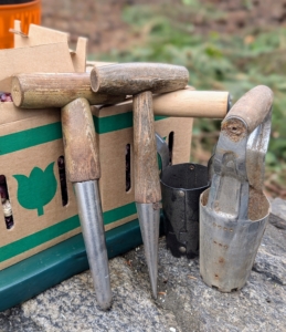 There are several different tools used for planting bulbs depending on the size of the bulb. My gardeners use T-handled dibbers, which are pressed into the soil to make holes, and traditional bulb planters with six inch barrels for removing soil and then dropping it back into the hole over the bulb.