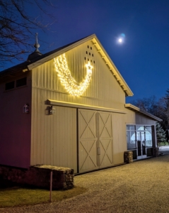 This shooting star is hung above the sliding doors of my Equipment Barn. By night fall, the lights look so beautiful. Do you know what a true shooting star is? A shooting star is actually a small piece of rock or dust that hits Earth’s atmosphere from space. It moves so fast that it heats up and glows as it moves through the skies. Astronomers call them meteors. Most meteors burn up before they even reach the ground. Happy holiday decorating!