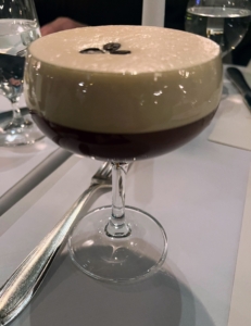 This is an espresso martini, which is a cold caffeinated drink made with espresso, coffee liqueur, and vodka. It is not a true martini as it contains neither gin nor vermouth, but is one of many popular drinks that use "martini" in its name.