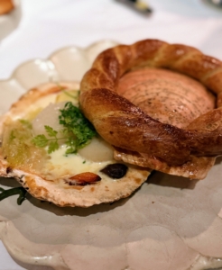 Coquille Saint Jacques Normande is scallops served with apple, vegetables, beurre blanc, calvados, and mushroom brioche.