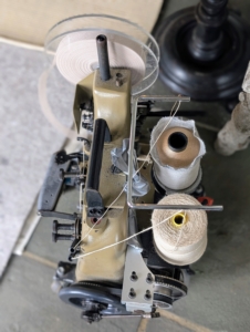 This is a carpet edge serger machine, or carpet-binding machine. It is used to quickly and easily sew a border around the perimeter of a carpet.