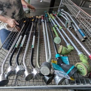 First, Ryan organizes all the watering wands. We use these all year round. They're perfect for watering all the hanging pots as well as harder to reach pots in my greenhouse and hoop houses.