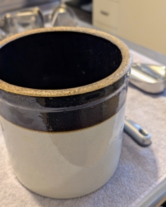 Vintage and antique crocks can be used to hold utensils on the counter. These strong, large jars are durable and easy to keep clean. They can be found at tag sales and consignment shops, or new in stores and online.