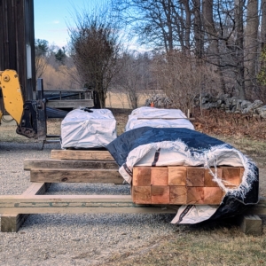 The wood is stored raised off the ground to help keep it dry and free from mold and rot.