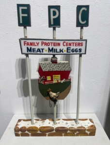 Scott Filar and Joy O'Shell had this fun object - a business promotional sign for Family Protein Centers. It was built using scraps - dowels, a toy, individual glass letters, and wood. It focuses on the nutrition pyramid of the 1950s which included eggs, meat and milk.