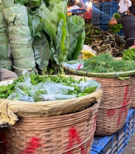 This is a stall in the vegetable market. Baskets are displayed early in the morning filled with fresh greens.