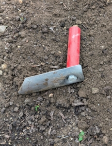 He uses a Right Angle Trowel designed for ergonomic planting from Johnny's Selected Seeds.