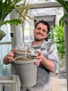 Once the plants are all potted, Ryan carries them next door to the greenhouse where they can be thoroughly watered.